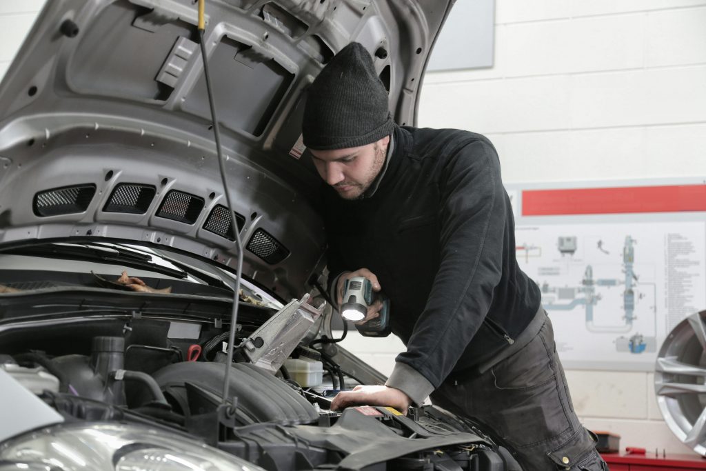 Autostar technician conducting vehicle inspection and mechanical repairs, hood open in their Christchurch workshop.